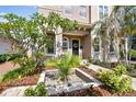 Inviting home featuring a lovely front door with a wreath, surrounded by lush tropical landscaping at 407 S Fremont Ave # B, Tampa, FL 33606