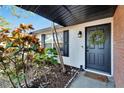 Close-up of the front door with a wreath, complemented by vibrant landscaping, shutters and a cozy welcome mat at 502 Timber Bay E Cir, Oldsmar, FL 34677