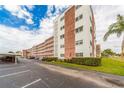 View of the condominium building, showcasing its architectural design with a parking area and landscaped grounds at 5501 80Th N St # 207, St Petersburg, FL 33709