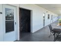 Condominium hallway featuring a staircase, multiple doors, and outdoor seating area at 5501 80Th N St # 207, St Petersburg, FL 33709