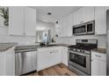 Well-lit modern kitchen featuring white cabinets, stainless steel appliances, and subway tile backsplash at 5865 Meadowpark Pl, Lithia, FL 33547