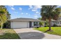 Inviting single-story home with a well-kept lawn, mature landscaping, and a paved driveway leading to an attached garage at 905 W Fribley St, Tampa, FL 33603