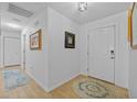 Bright hallway with wood-look floors, white walls, and decorative rugs creating a welcoming entrance at 905 W Fribley St, Tampa, FL 33603