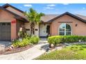 Inviting front exterior with a brick facade, landscaped garden, and walkway leading to a white front door at 9202 Jena Rd, Spring Hill, FL 34608