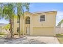 Charming home exterior with a well-manicured lawn, mature palm trees, and a two car garage at 10311 Frog Pond Dr, Riverview, FL 33569