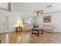 Bright living room with wood flooring, neutral paint, and two sofas with decorative pillows at 10311 Frog Pond Dr, Riverview, FL 33569