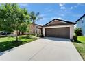 Home features a well-kept lawn, and long driveway, and an attached two-car garage at 11121 Hudson Hills Ln, Riverview, FL 33579