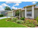 Landscaped front yard with colorful flowers enhancing the curb appeal of the home at 11148 Hollander Ave, Hudson, FL 34667