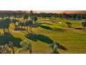 Scenic golf course view with lush green grass, mature trees, and tranquil water feature at sunset at 12300 Vonn Rd # 7107, Largo, FL 33774