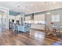 Spacious kitchen with white cabinetry, stainless steel appliances, a large island, and wood floors at 13706 Osprey Fern Ln, Riverview, FL 33569