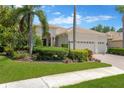 Charming single-story home showcasing lush landscaping, including palm trees and verdant lawns at 13872 Siena Loop, Lakewood Ranch, FL 34202