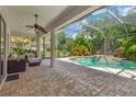 Covered patio with comfortable seating area overlooking the screened-in pool and lush backyard at 13872 Siena Loop, Lakewood Ranch, FL 34202