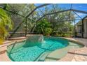 Screened-in pool with spa and water feature, surrounded by lush landscaping offering a private retreat at 13872 Siena Loop, Lakewood Ranch, FL 34202