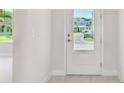 Bright foyer featuring a white door, neutral walls, and lovely natural light at 1599 Running Tide Pl, Sarasota, FL 34240