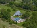Aerial view of a charming home with in-ground pool, screened in porch, and detached garage at 16326 Kalli Way, Dade City, FL 33523
