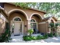 Inviting front entrance with arched doorway, complemented by well-manicured landscaping and neutral exterior colors at 17321 Oak Ledge Dr, Lutz, FL 33549