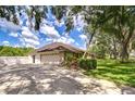 Spacious two-car garage and driveway, complemented by manicured greenery and garden at 17917 Clear Lake Dr, Lutz, FL 33548