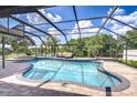 Screened-in pool area features a hot tub, seating area, and views of the serene lake at 17917 Clear Lake Dr, Lutz, FL 33548