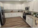 Modern kitchen featuring white cabinets, stainless steel appliances, and granite countertops at 2026 Sidney St, Clearwater, FL 33763