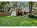 Spacious backyard featuring lush green grass, mature trees, and a wooden fence at 2838 Timber Knoll Dr, Valrico, FL 33596