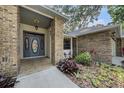 Inviting front entrance with brick accents, a covered porch, and beautifully landscaped garden beds at 2838 Timber Knoll Dr, Valrico, FL 33596