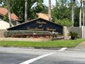 Community entrance sign 'Clusters at Carrollwood Springs' amidst vibrant landscaping and manicured lawns at 3902 Shoreside Cir, Tampa, FL 33624