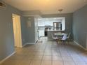 Bright dining area with tile flooring, seating, and a view of the updated kitchen with stainless appliances at 4008 Ashford Green Pl # F101, Tampa, FL 33613