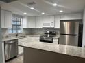 Modern kitchen featuring stainless steel appliances, granite countertops, and ample cabinet space at 4008 Ashford Green Pl # F101, Tampa, FL 33613