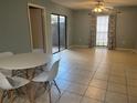 Open living room featuring tile floors, a ceiling fan, and a sliding glass door to a private patio at 4008 Ashford Green Pl # F101, Tampa, FL 33613
