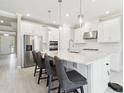 Bright kitchen featuring white cabinets, stainless steel appliances, and a large center island with seating at 4709 Isonzo Way, Wesley Chapel, FL 33543