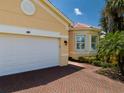 A home with a white garage door and brick driveway offers a clean and inviting exterior at 4821 Grand Banks Dr, Wimauma, FL 33598
