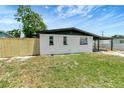 A single-story home featuring a well-maintained lawn and a carport with ample parking space at 6403 N Lois Ave, Tampa, FL 33614