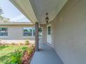 View of the home's facade, showing front door, decorative landscaping, and overhead lighting at 9292 120Th Ln, Seminole, FL 33772