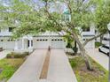 Charming townhome exteriors feature attached garages, lush landscaping, and a shared driveway enhanced with decorative stones at 9812 Indian Key Trl # 84, Seminole, FL 33776