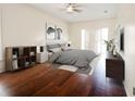 Bright bedroom with modern gray decor, hardwood floors, and a sliding glass door at 9912 Chris Craft Ct, Tampa, FL 33615