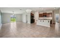 Open-concept living area with tile flooring, a sliding glass door and a modern kitchen at 10326 Boggy Moss Dr, Riverview, FL 33578