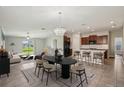 Staged living and dining area featuring a chandelier, modern furniture, and neutral color palette at 10326 Boggy Moss Dr, Riverview, FL 33578