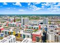 An aerial view shows the colorful modern condo buildings among the city landscape with a cloud-filled blue sky at 1120 E Kennedy Blvd # 1127, Tampa, FL 33602
