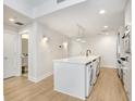A modern kitchen featuring a white island, stainless steel appliances, and light wood floors at 1120 E Kennedy Blvd # 1127, Tampa, FL 33602