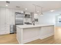 A modern kitchen featuring a white island, stainless steel appliances, and light wood floors at 1120 E Kennedy Blvd # 1127, Tampa, FL 33602