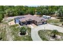 Single-story home with a screened-in pool, three-car garage, circular driveway and a spacious yard at 13110 Manistee Rd, Weeki Wachee, FL 34614