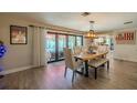Bright dining room featuring a wooden dining table, floor-to-ceiling windows, and light wood flooring at 1503 Albemarle Ct, Dunedin, FL 34698