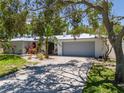 Beautiful single story home with an attached two car garage, lush landscaping, and a metal roof at 1503 Albemarle Ct, Dunedin, FL 34698