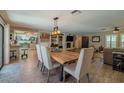 Open concept living and dining room featuring wood floors, a stone fireplace, and white accents at 1503 Albemarle Ct, Dunedin, FL 34698