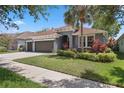 Attractive single-Gathering home with a gray exterior, well-kept lawn, and a three-car garage at 15711 Starling Dale Ln, Lithia, FL 33547