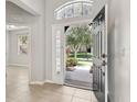 Welcoming foyer with an open front door view and a decorative transom window above at 15711 Starling Dale Ln, Lithia, FL 33547