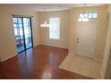 Open-concept living room features a sliding glass door, stylish lighting, and tile entry at 16618 Kingletside Ct, Lithia, FL 33547