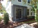 Exterior view of screened-in porch featuring dark metal frame and easy access to the grassy yard at 16618 Kingletside Ct, Lithia, FL 33547
