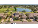 Expansive aerial view of the home, showcasing its scenic surroundings by the pond and golf course at 2407 Kensington Greens Dr, Sun City Center, FL 33573