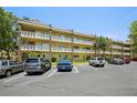 Condo exterior featuring balconies, ample parking, and nicely manicured landscaping with palm trees at 2416 World Parkway Blvd # 26, Clearwater, FL 33763